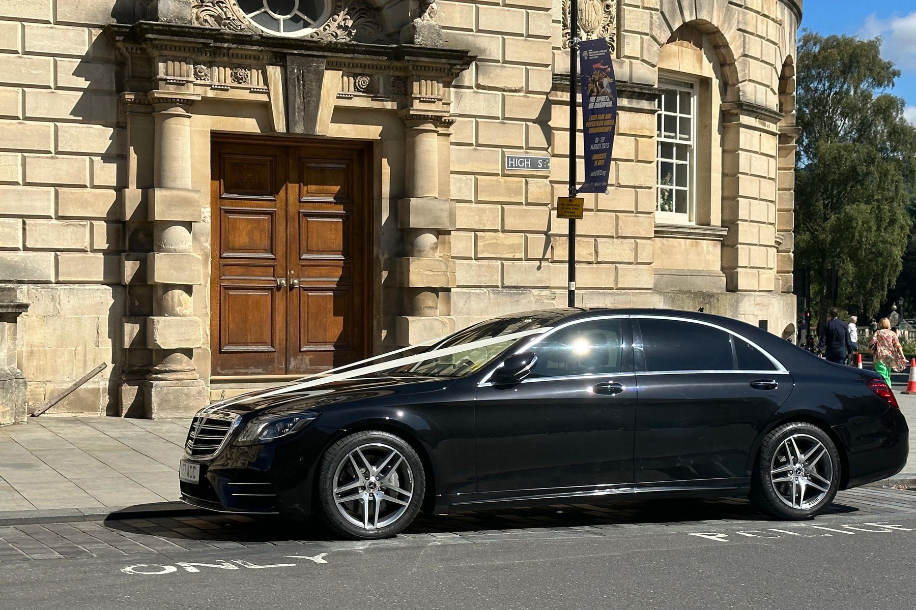 Black Mercedes S-Class parked outside a carved Bath-stone doorway in the city centre