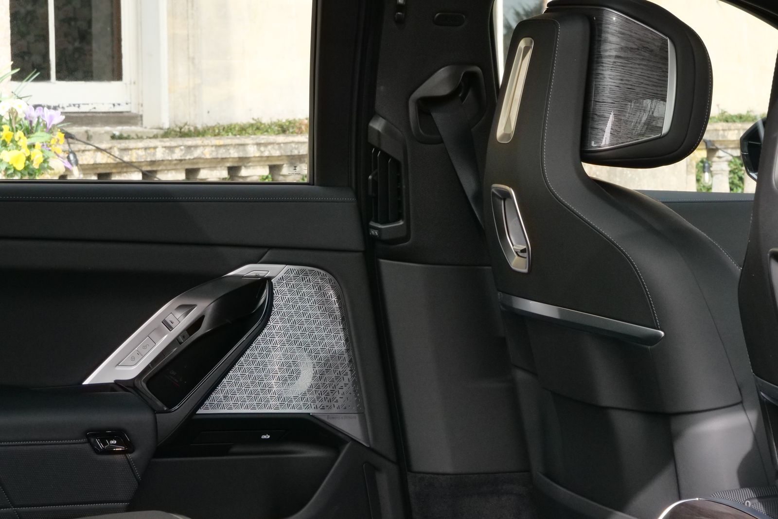 Rear passenger seat of an executive saloon, with a Bath-stone house through the window